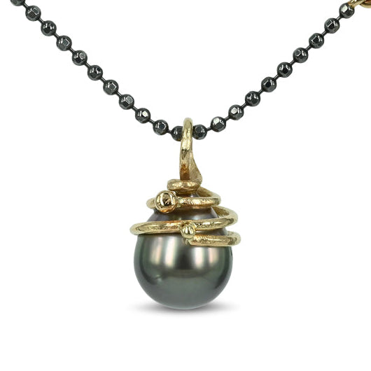 14 kt. Guld vedhæng med tahitiperle
Unik mørk tahiti perle, med 14 kt. guld top, der snor sig elegant omkring perlen.