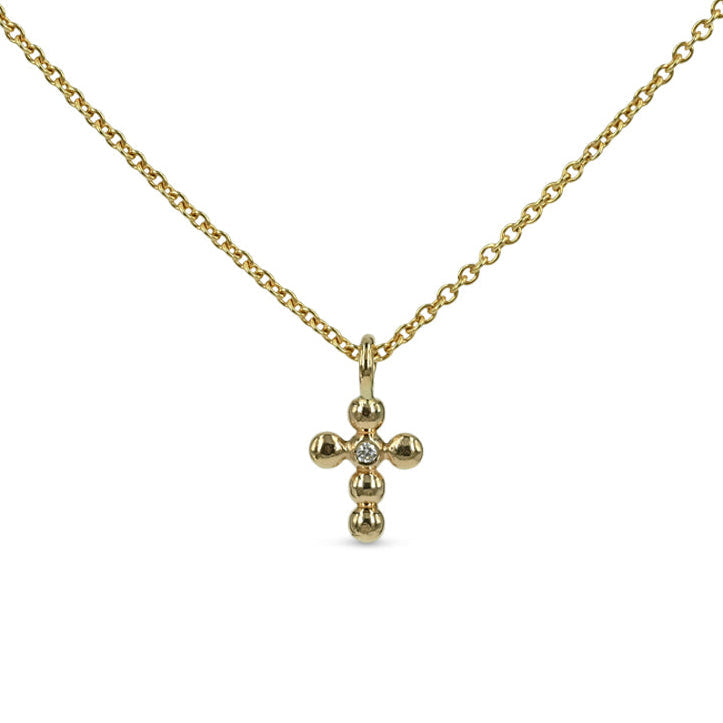 guldkors lavet af de finest kugler, i midten sidder en diamant