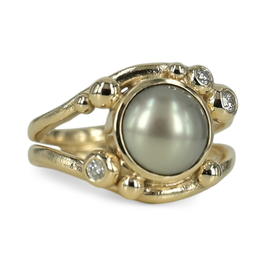 14 kt. guldring med Tahiti perle 10 - 10½ mm. samt 0.16 ct. tw vvs brillanter. Smuk fyldig ring i bløde organiske former, ringen smaller ind under fingeren så den får et smuk sving i ringskinnen.