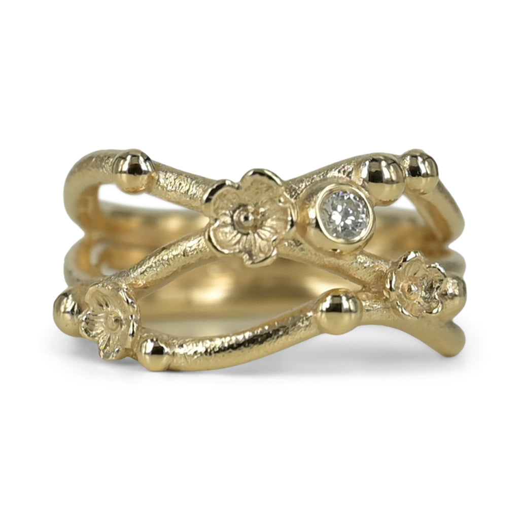 Guldring med let materet overflade, skabt i 14 kt. guld isat smuk 0,10 ct tw vvs brillant. Ringen er skabt i organisk form og danser om din finger som fine blomster stiklinger. Et smykke fyldt med eventyr, fra de smukke blomster og den uendelige skønhed fra guldet og brillanten bliver smykket magisk og fortryllende.