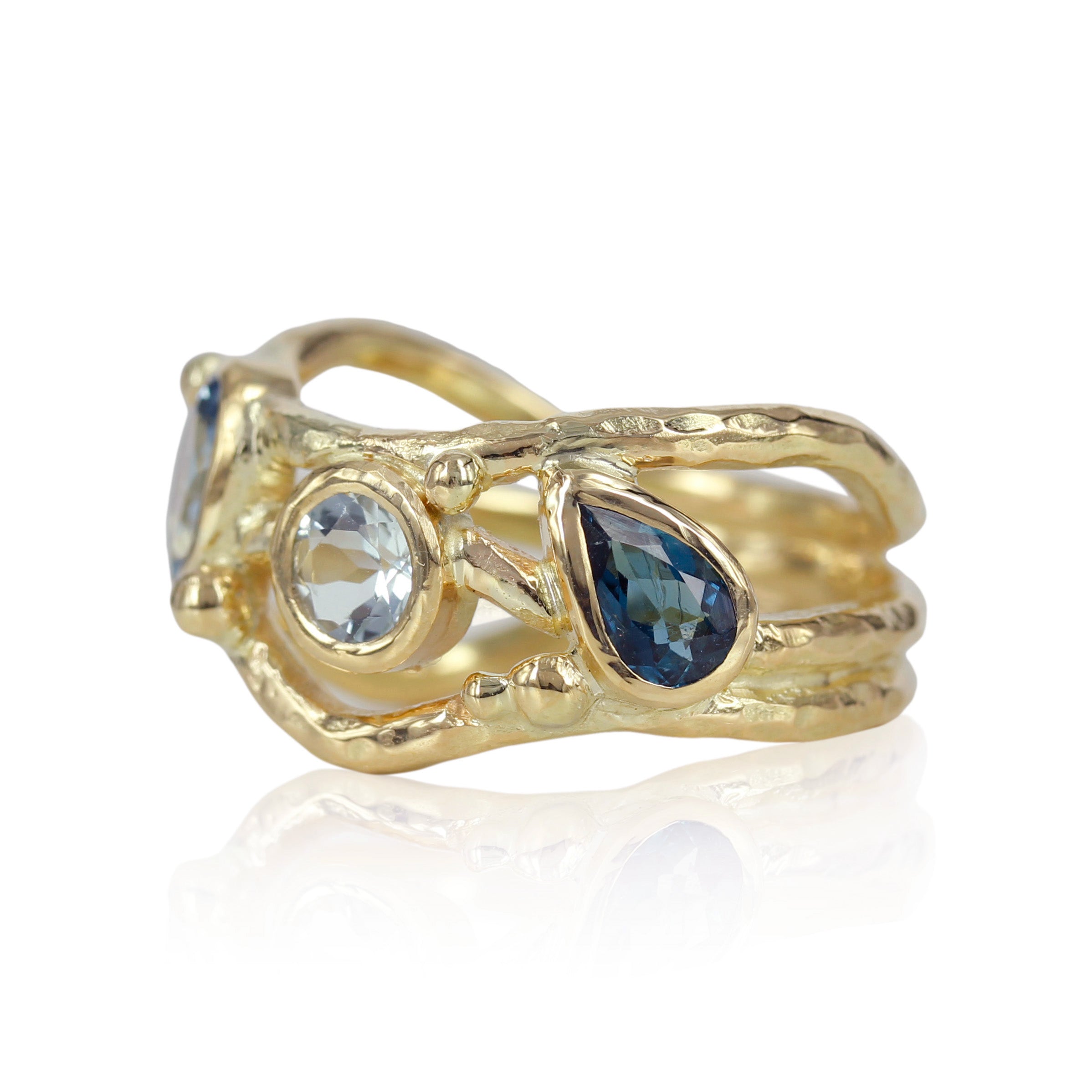 Organisk unika guld ring med lyseblå safir og turmaliner der svinger på ringskinnen. .