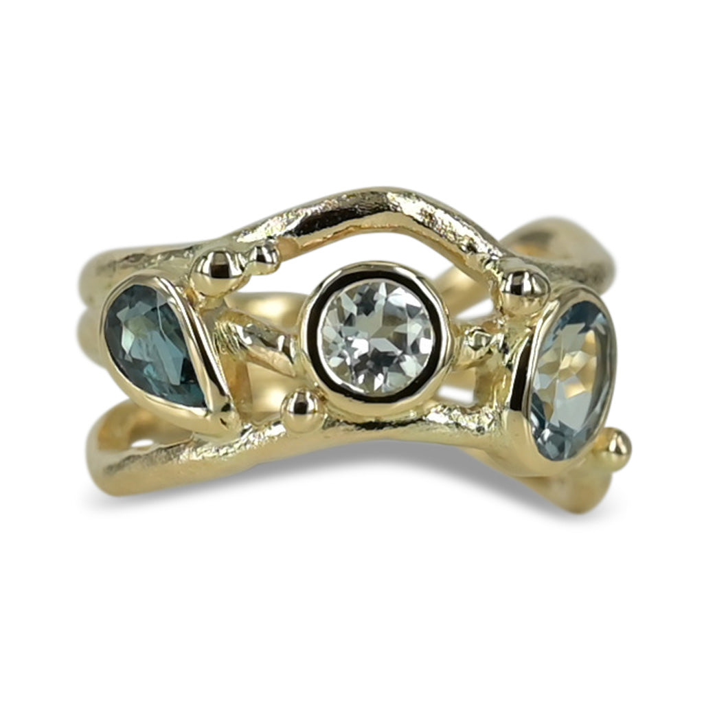 Organisk unika guld ring med lyseblå safir og turmaliner der svinger på ringskinnen. .