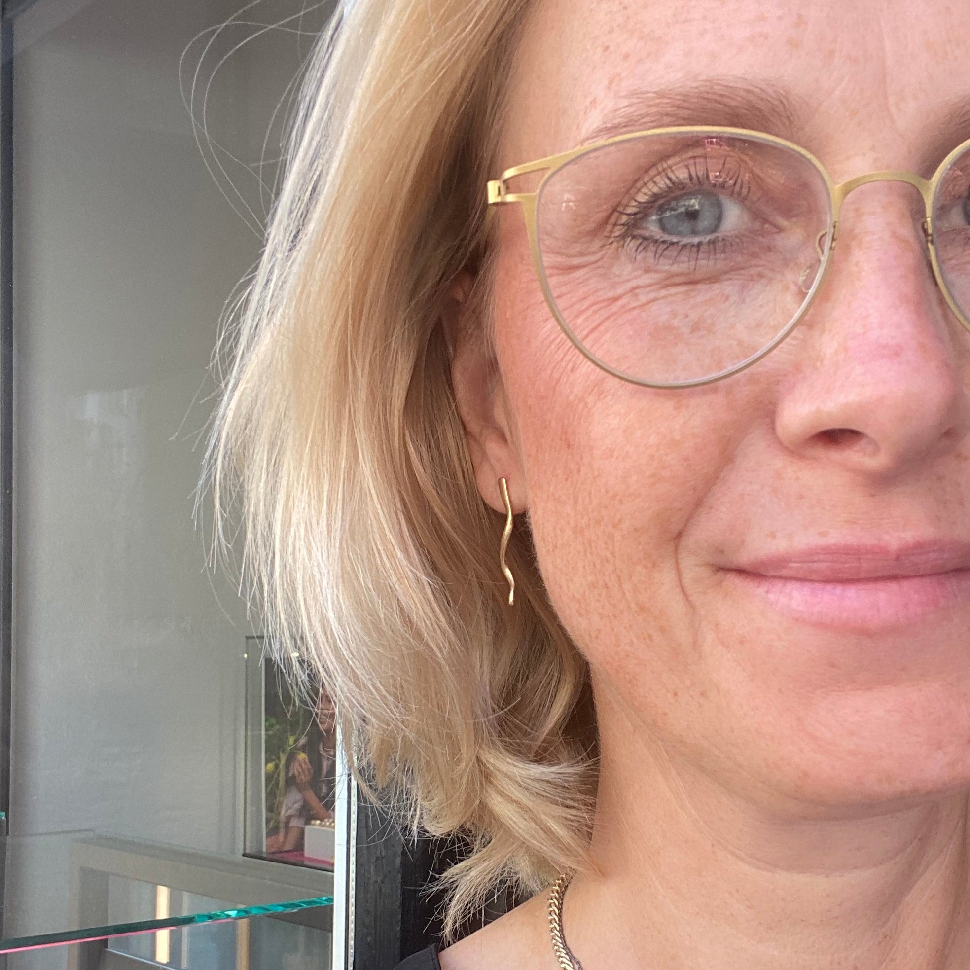 Styling af halskæde designet som uendelighedstegn vises med guldøreringe