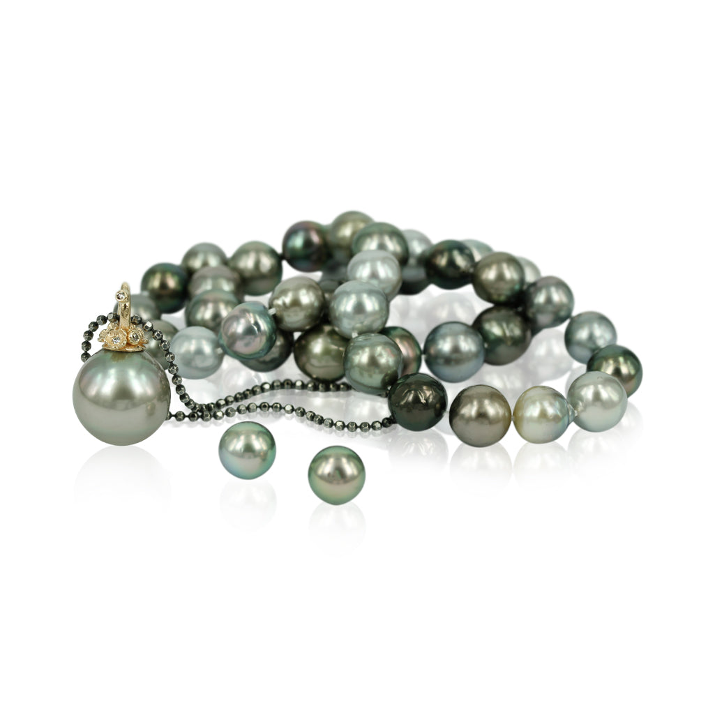 Smukt unika perlevedhæng med guldblomster og diamanter, vises med tahitiperler