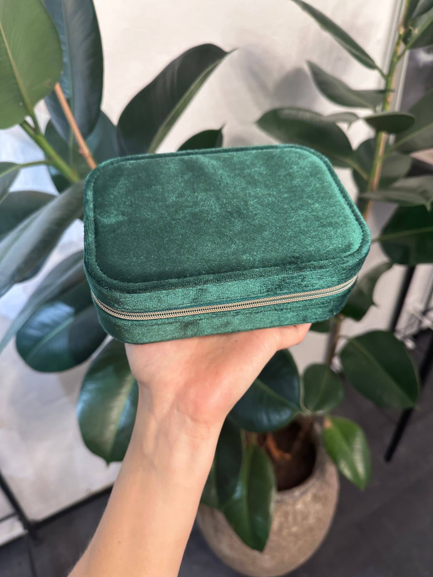 Grønt velour smykkeskrin med lynlås, perfekt til opbevaring af smykker under rejser.