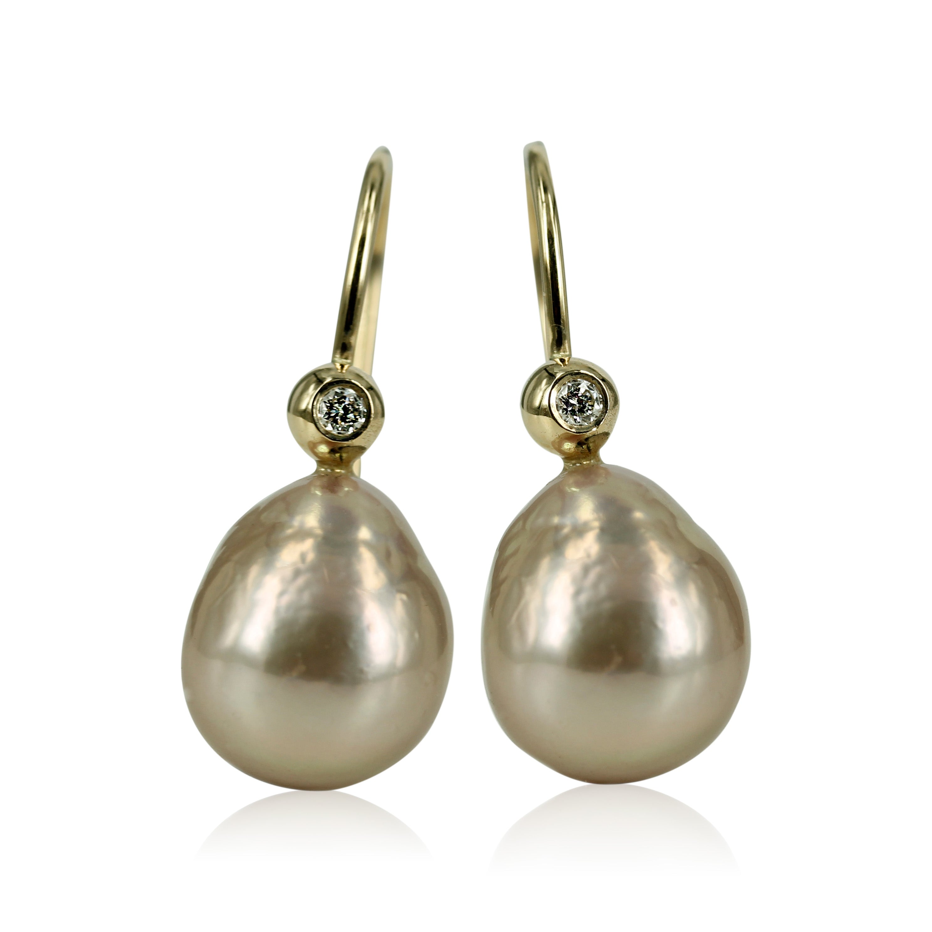 14 kt. Perleøreringe med smukke diamanter & rosa ferskvandsperler Klassiske 14 kt. ørekroge, med funklende brillanter og smukke 10x12 mm. let barokke rosa ferskvands perler. Den fine fatning med brillant - gør øre smykket klassisk med et moderne look.
