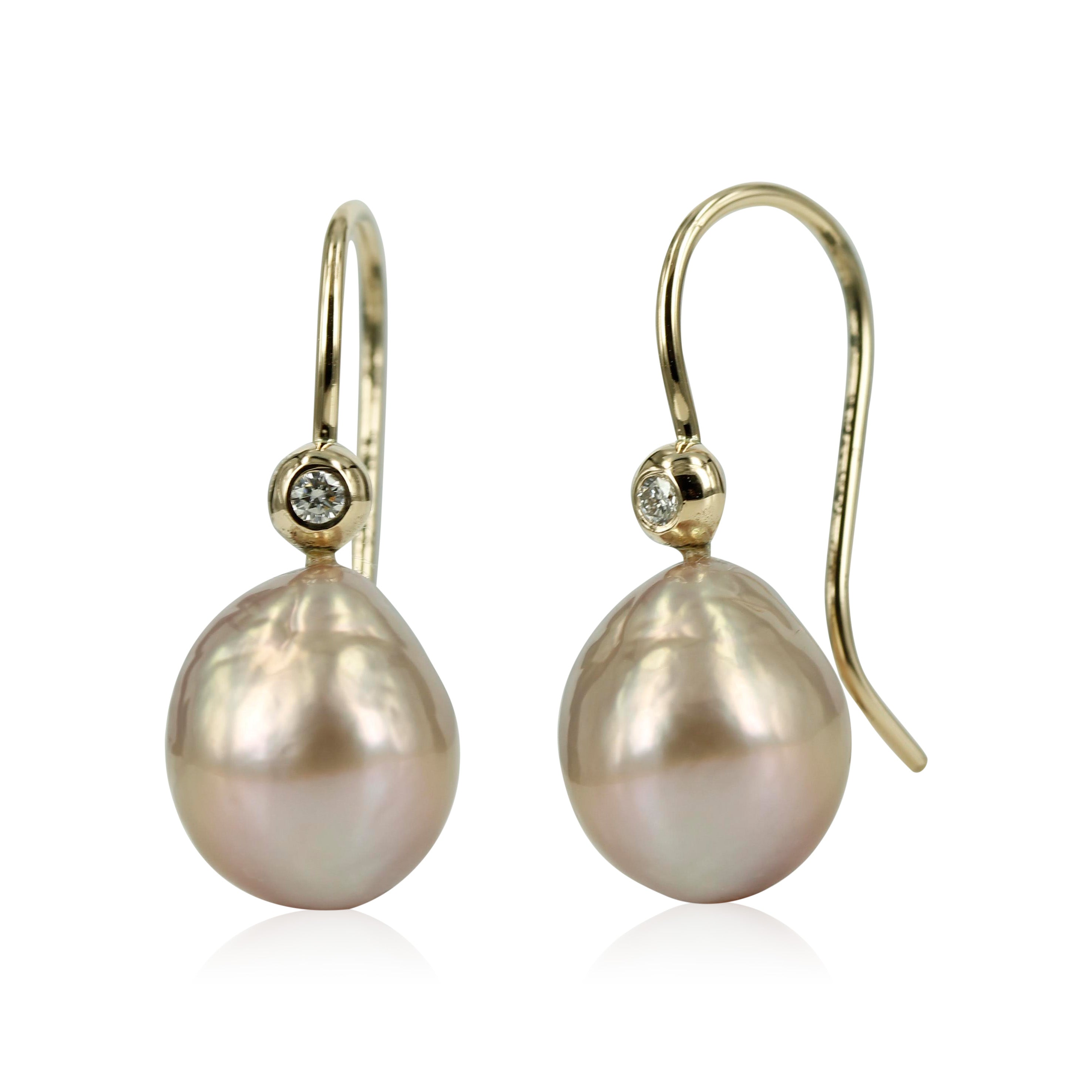 14 kt. Perleøreringe med smukke diamanter & rosa ferskvandsperler Klassiske 14 kt. ørekroge, med funklende brillanter og smukke 10x12 mm. let barokke rosa ferskvands perler. Den fine fatning med brillant - gør øre smykket klassisk med et moderne look.