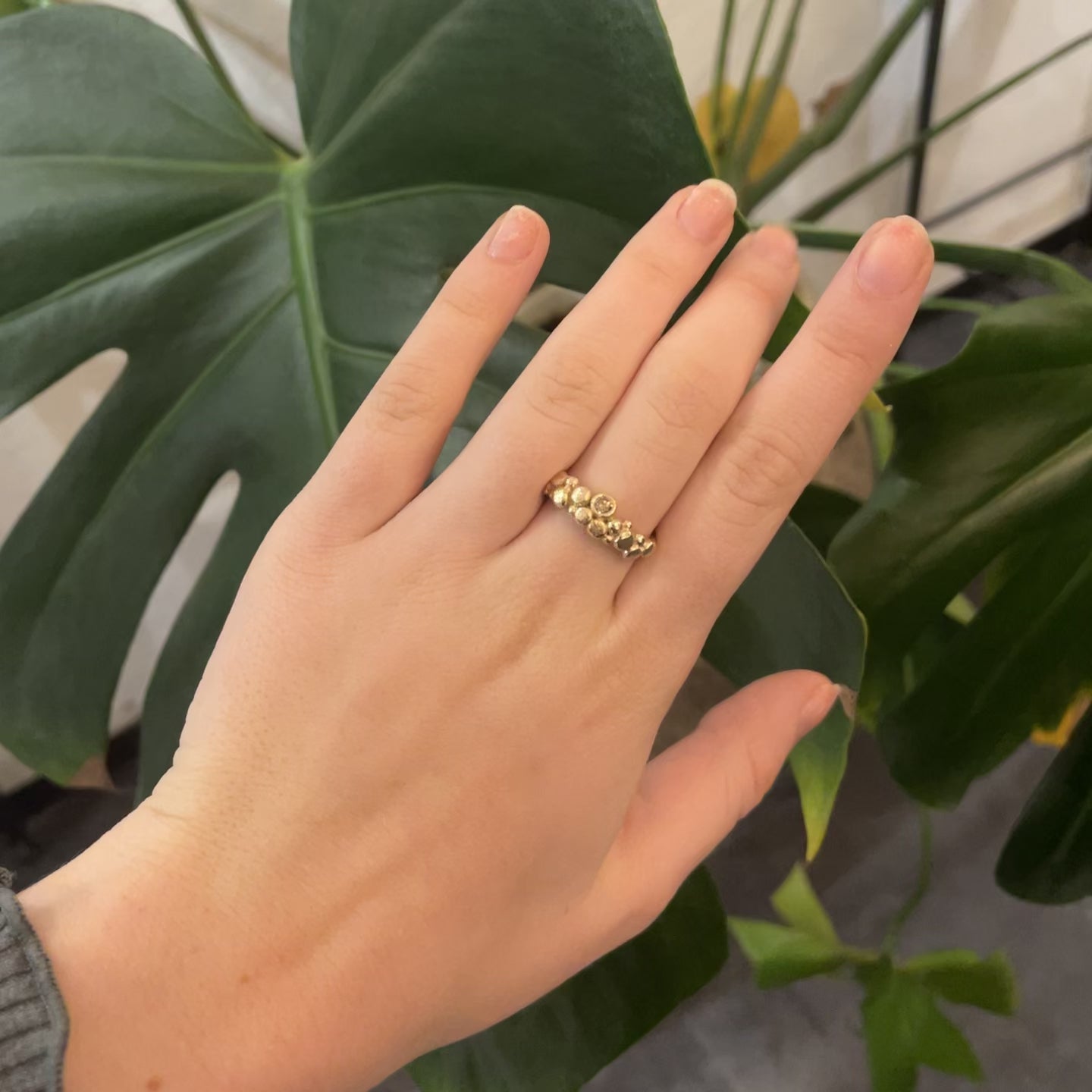 video - 14 kt. guld ring, i organiske design, små fine guld kugler der danser i tæt klase på fingeren, det giver et lidt råt udtryk, og den fine diamant giver et smukt mix af råt design & eksklusiv shine fra diamanten. Sten isat: , der er isat 1 x 0,07 ct brillant slebet champagnefarvet diamant.