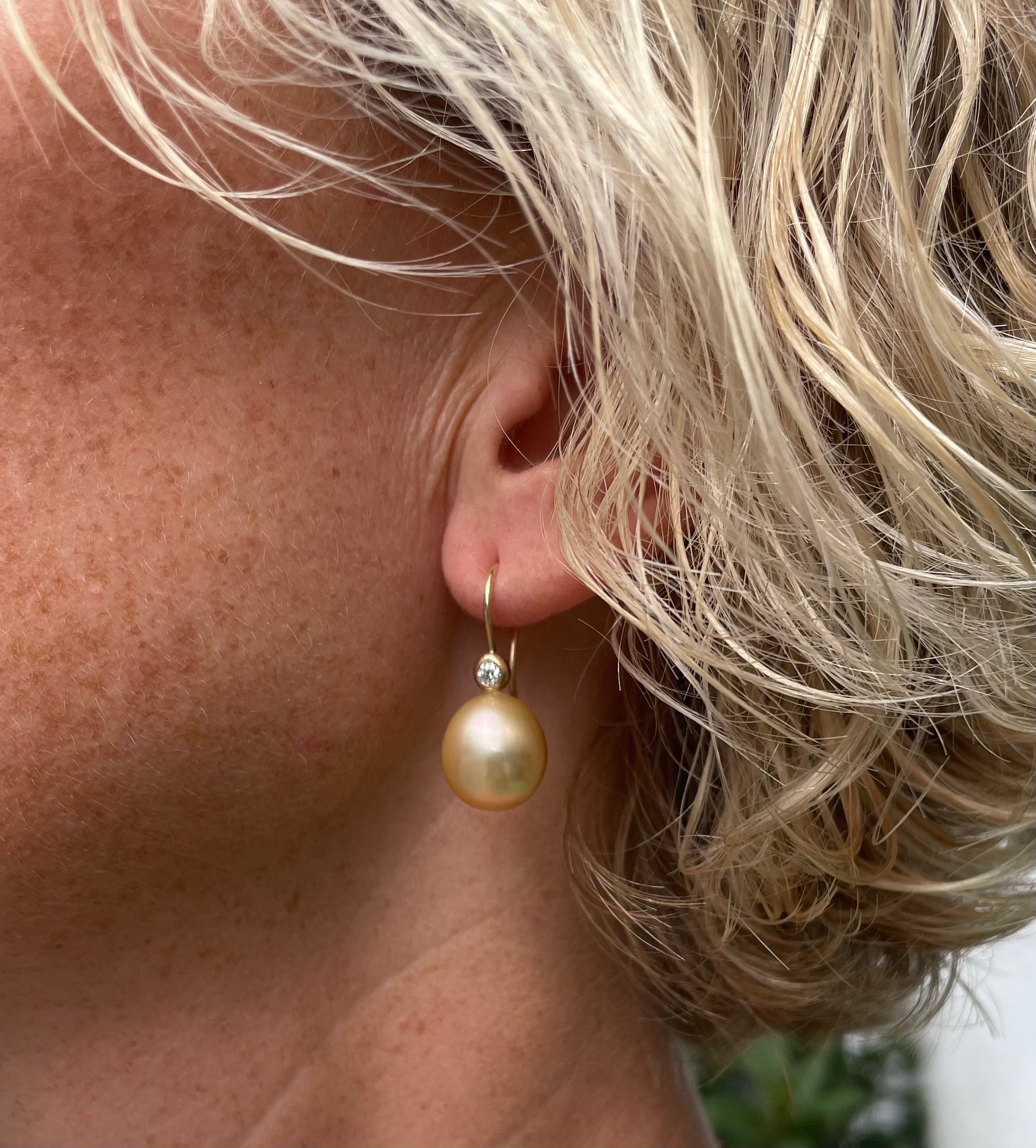 2. Klassisk 14 kt. ørekroge, med brillanter og smukke 12,5 x14,5 mm. dråbe formet gyldne South Sea perler. Den fine fatning med brillant - gør øre smykket klassisk med et moderne look. På billedet vises ørehængerne med 2 stk 0,10 ct brillant.
