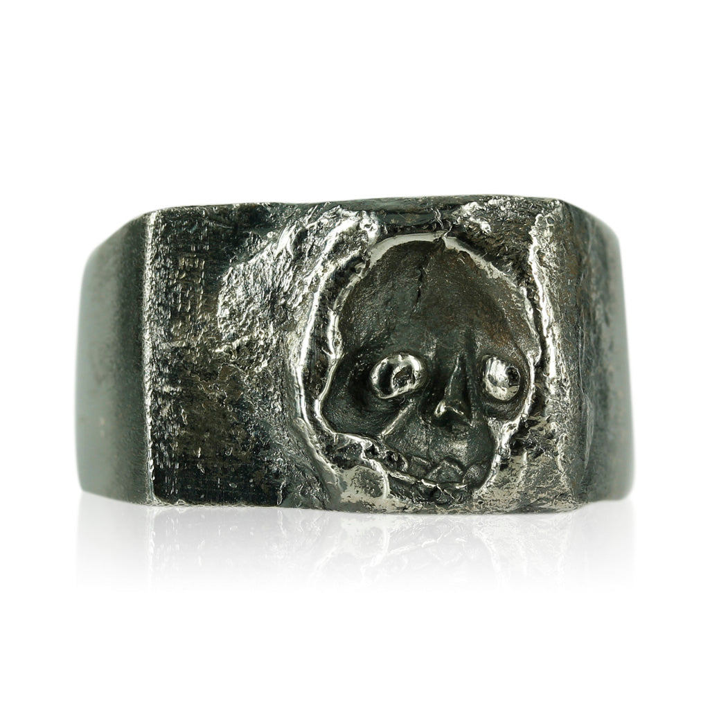 Rå og maskulin signet ring med dødningehovede motiv. Ringen er skabt i sølv og har en oxyderet overflade, som giver ringen et helt unikt udtryk.  Ringens top måler ca. 13 x 19 mm.