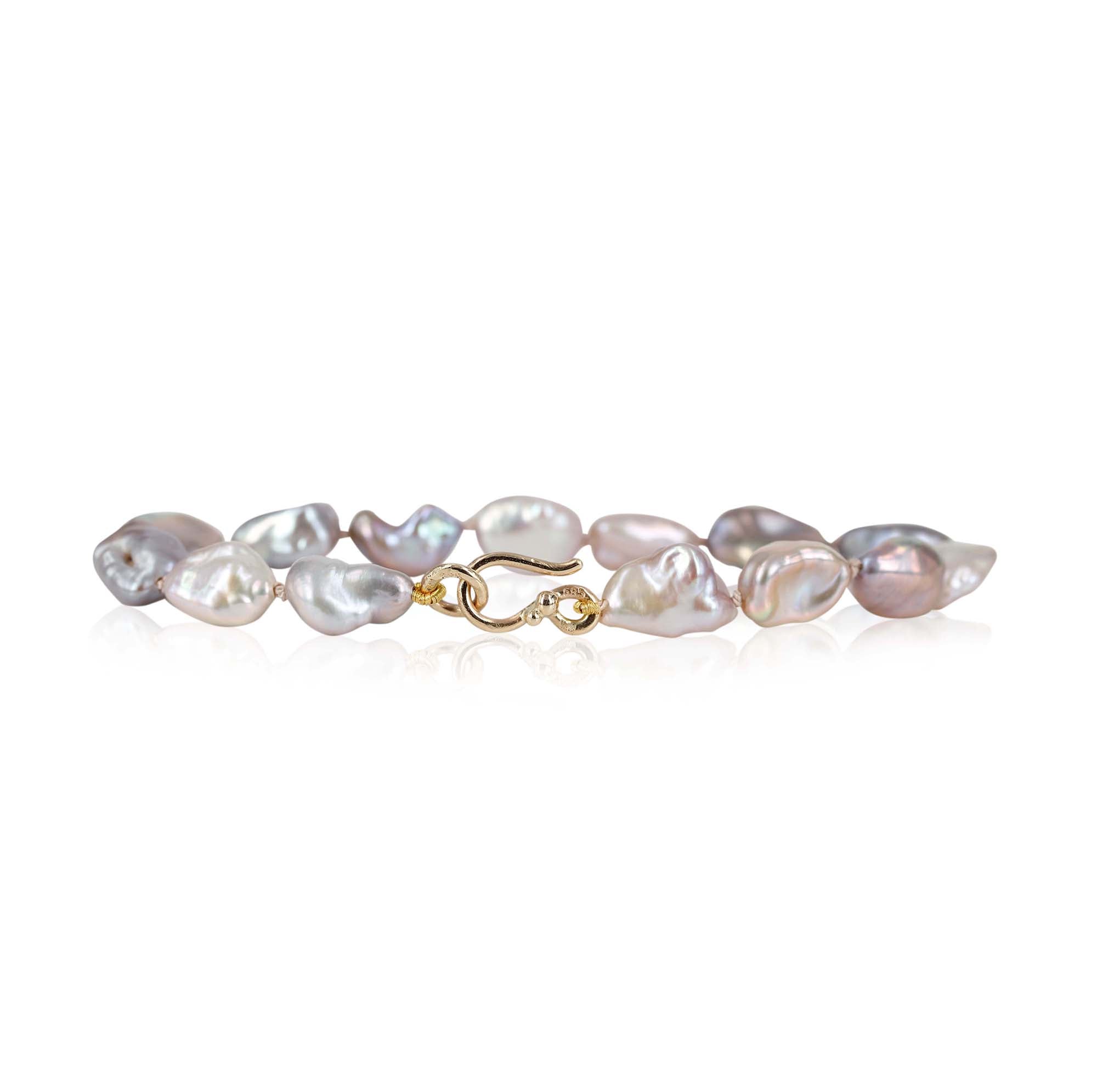 Smukt perlearmbånd med lyserøde ferskvands keshi perler, perlerne måler 6 x 10 mm ca. de har smuk perlemorsglans og skifter i farvespil fra lilla til lyserød.  Armbåndet har en fin lås i 14 kt. guld med guldkulger