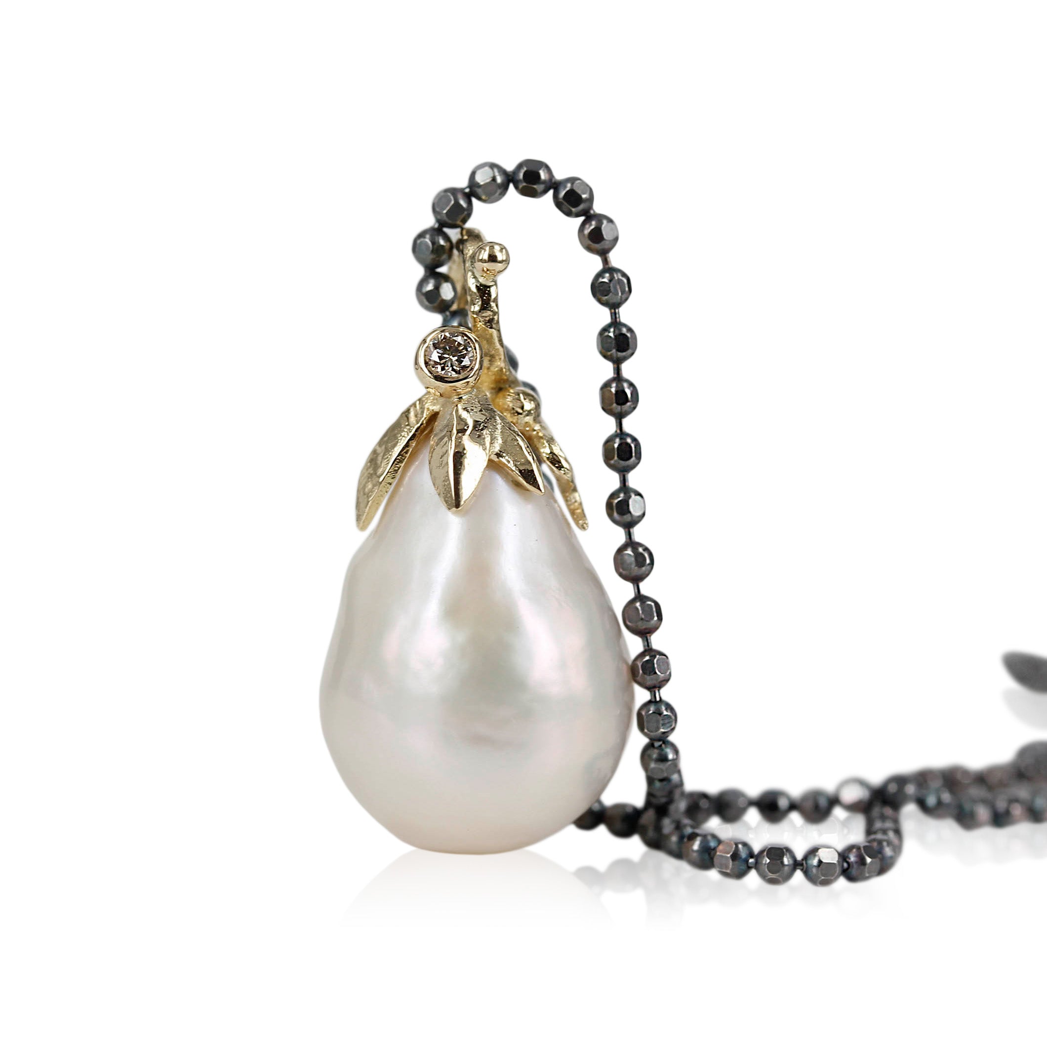 2. Nature -14 kt. Guld vedhæng med Barok ferskvandsperle & champagnefarver diamant.  Toppen er med fine blade i 14 kt guld, isat 1 stk. 0,03 ct champagnefarvet brillant slebet diamant.